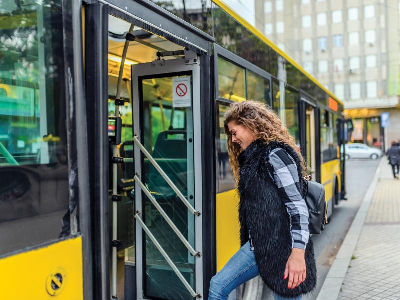 woman boarding a yellow city bus