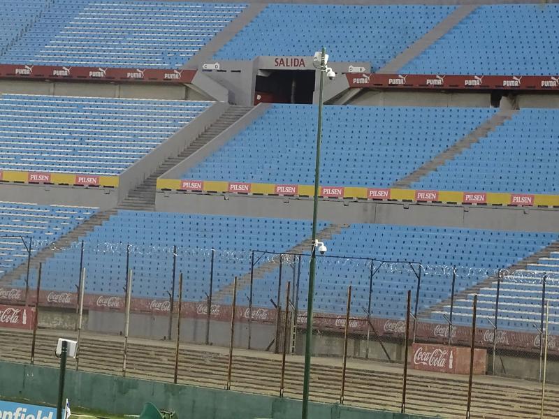 Empty stadium with blue seats and Axis Camera on a pole.