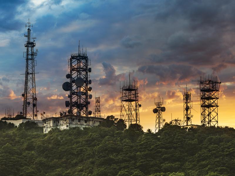 Several antenna towers in the sunset