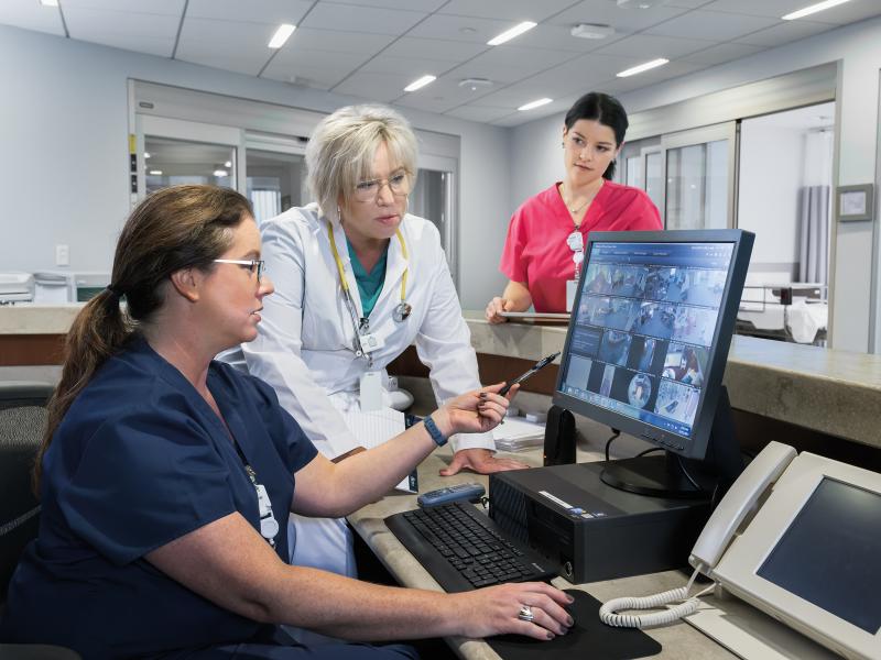 Doctor and nurses discussing while looking at a computer screen