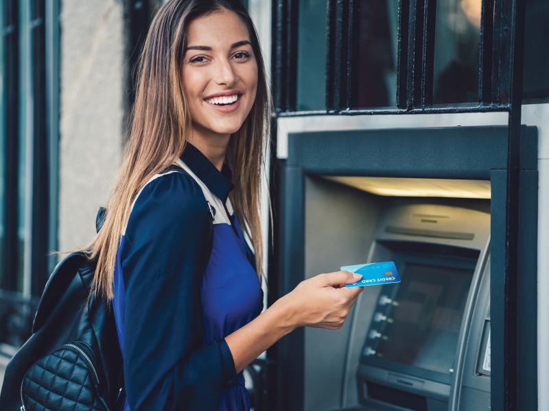 Woman smiling next to an ATM