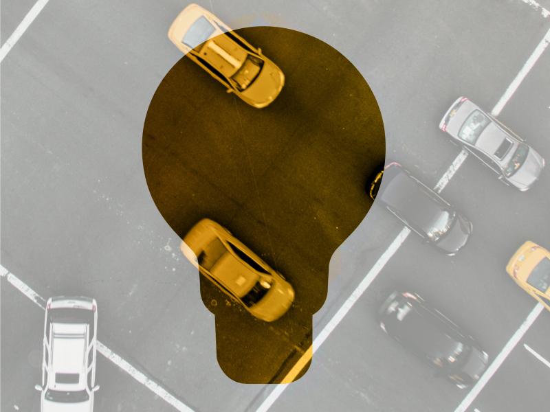 cars viewed from above in the background, a light bulb highlighted in yellow color in foreground