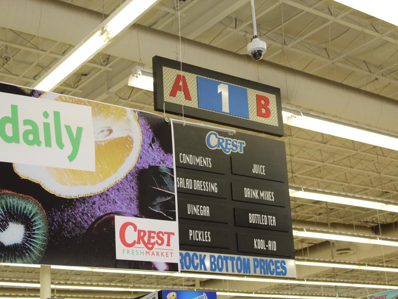 Aisle sign with ceiling camera at Crest Foods
