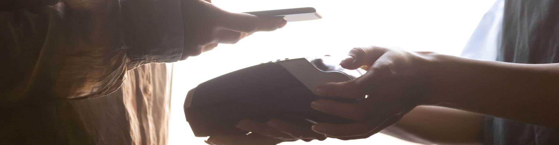 Zoomed view of a payment, one customer holding her phone above card machine