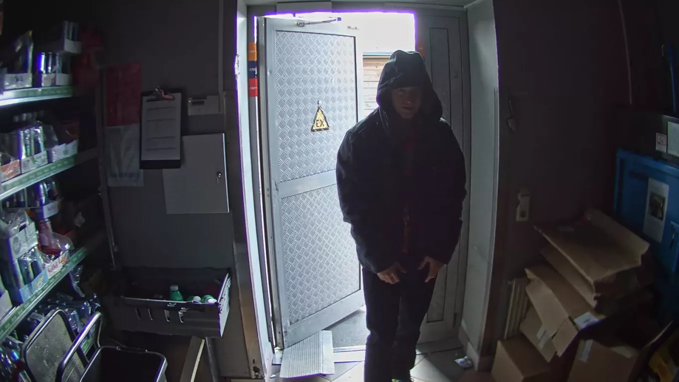 Man entering store in dark lighting