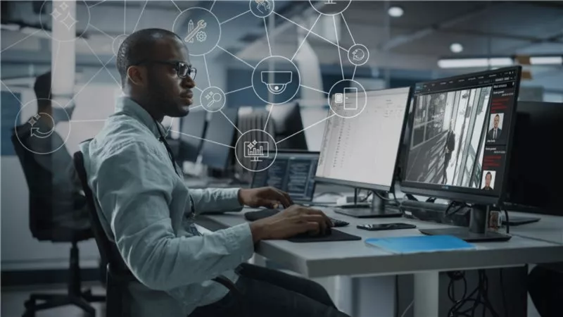 Man at a desk looking at two computer screens