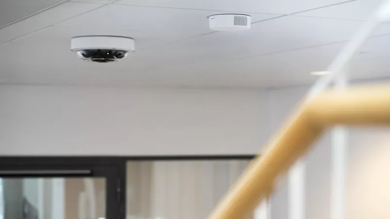 AXIS D6210 Air Quality Sensor and AXIS P3747-PLVE mounted in a staircase