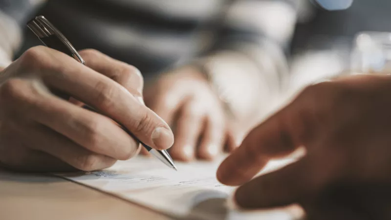 Hands signing grant paperwork