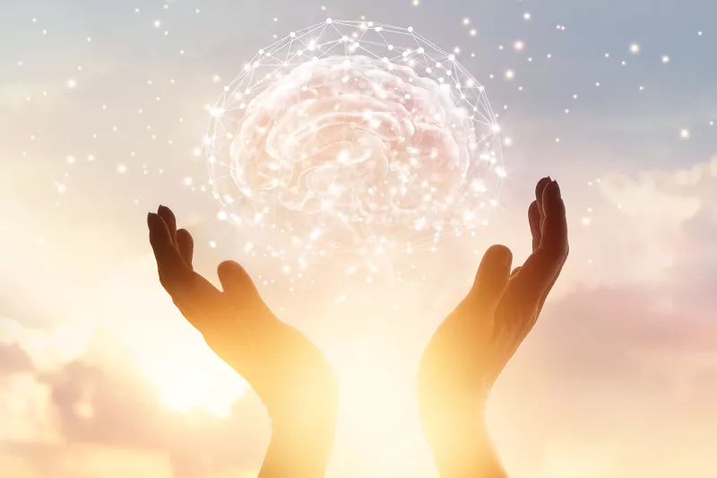 Hands holding a futuristic brain of light up into the air