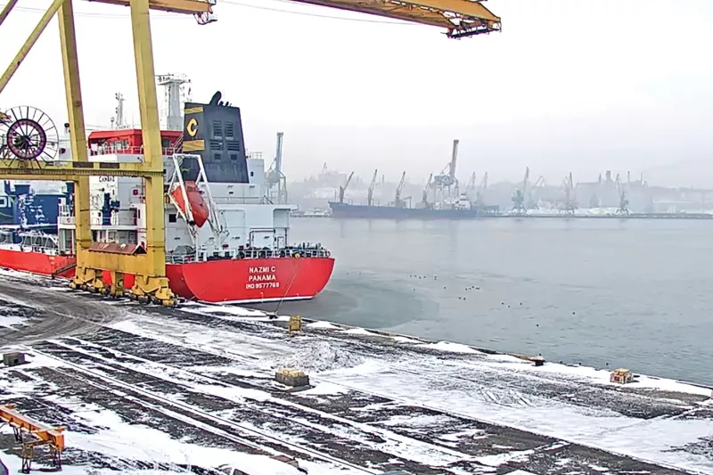Sea port in winter with a ship close by.