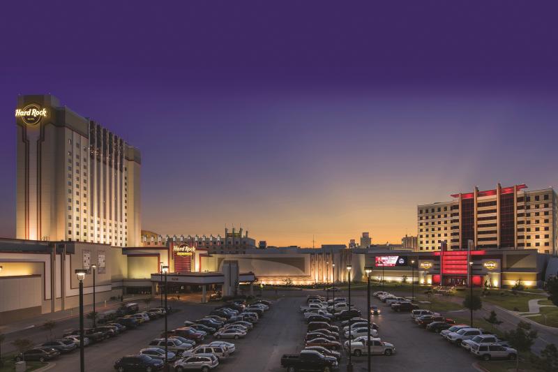 Hard rock hotel & casino by night, parking lot in front.