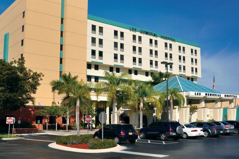 Lee memorial hospital with palm trees and parking lot in front.