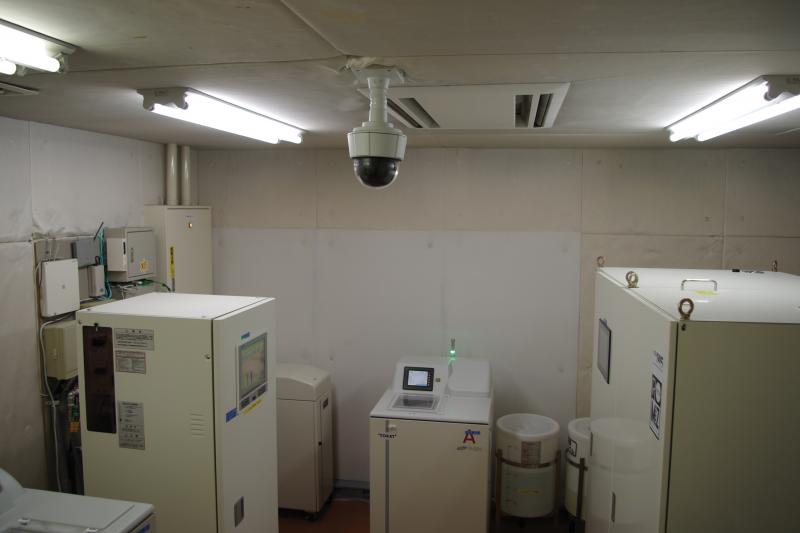 Axis camera on ceiling, system control room with white lockers.