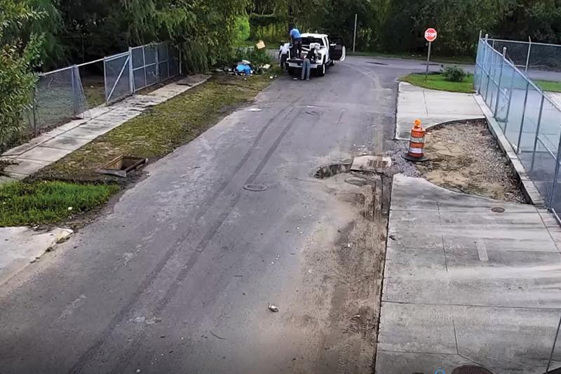 Screenshot of people in car performing illegal dumping of trash by roadside.