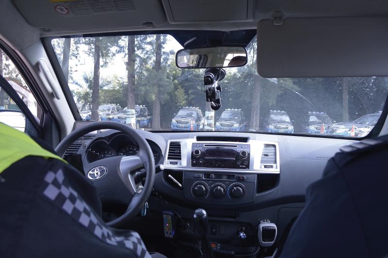 Inside a toyota car with two passengers viewing at several cars in front.