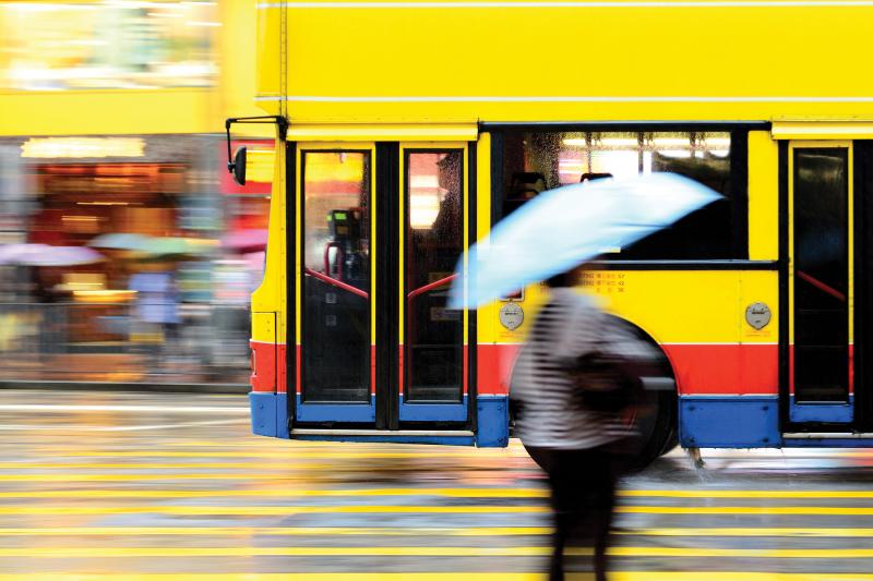 Blurry picture of yellow bus passing by on a street