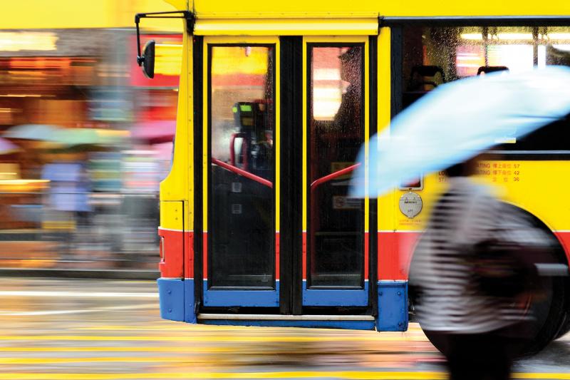 Blurry picture of bus passing by on  a street