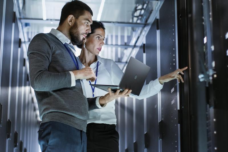 Two technicians working in a server room