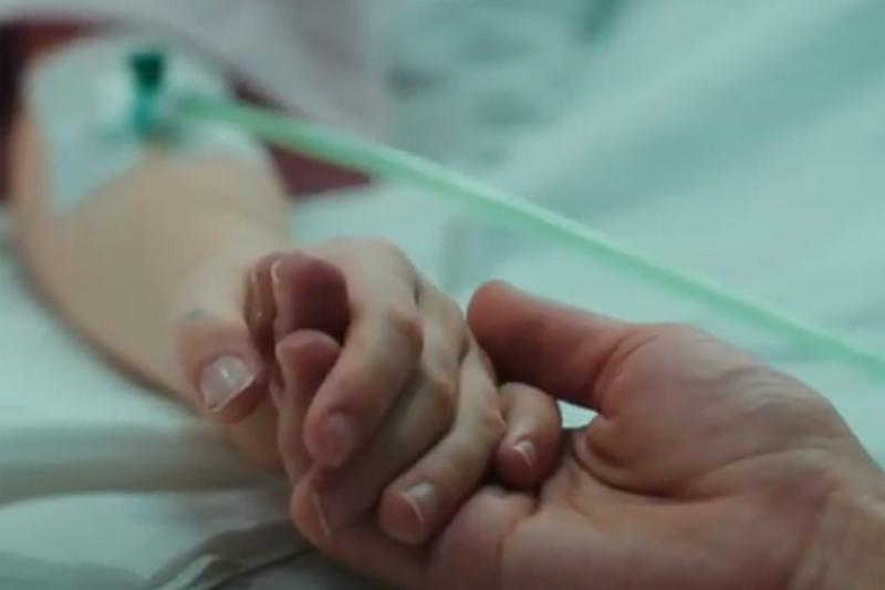 close up of a patient and relative holding hand