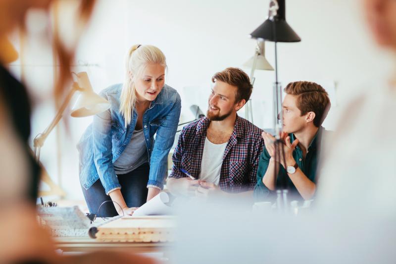 Woman explaining something for two men during a meeting.