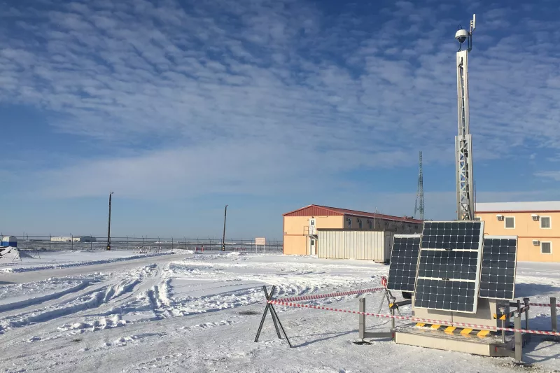 Pole-mounted security camera driven by solar energy in a snowy oil field