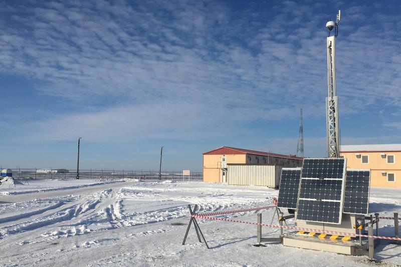 Pole-mounted security camera driven by solar energy in a snowy oil field