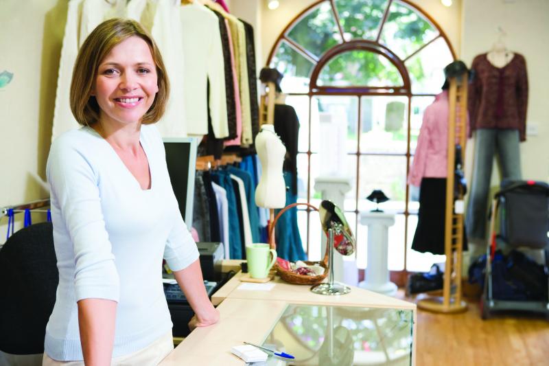 Female shop owner smiling in fashion store.