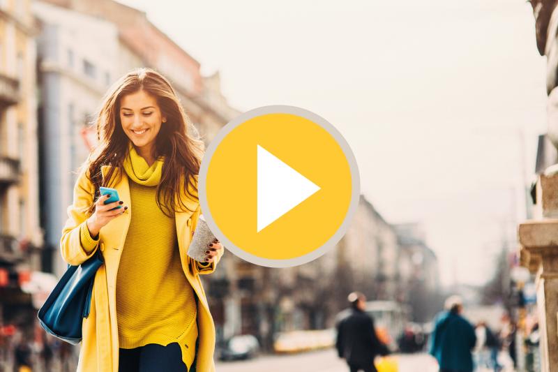 Woman in yellow clothes walks in a city