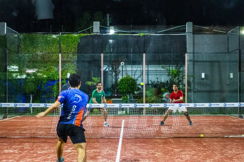 Two men playing indoor tennis at Club Deportivo