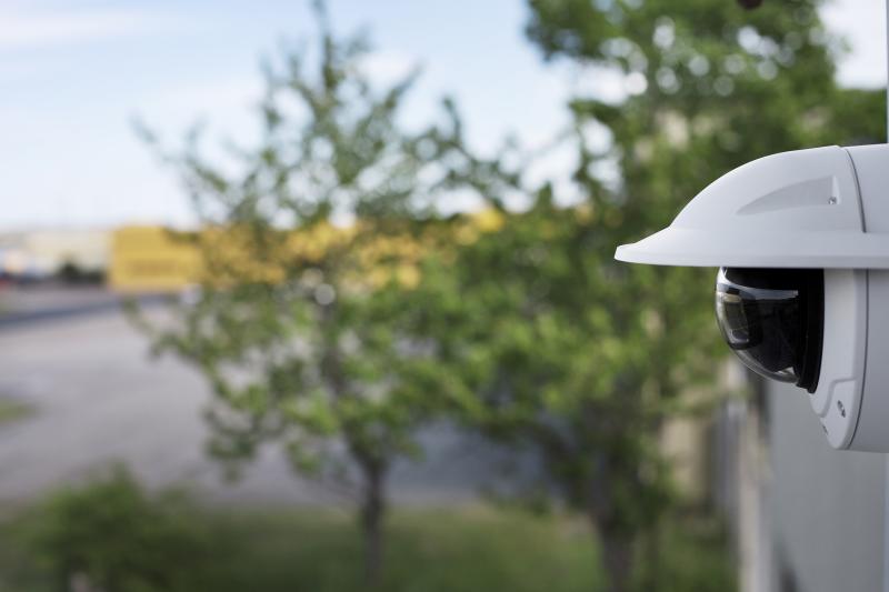 AXIS Q3518-LVE ip camera mounted on a wall in an outdoor environment