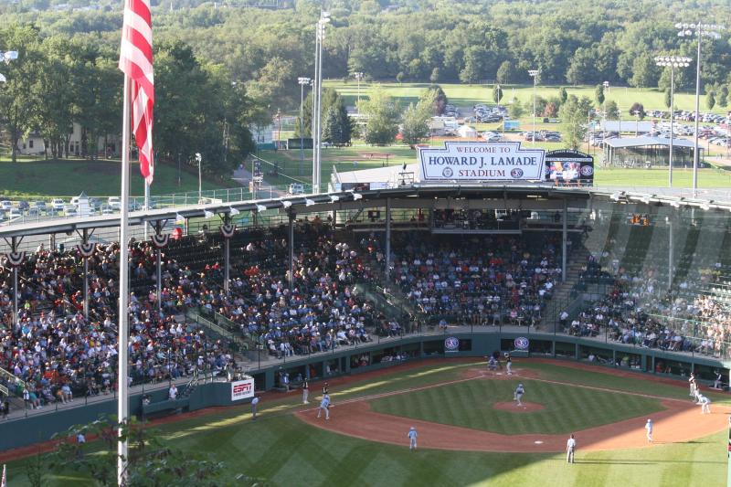View of grandstands, field, and flag at Little League world series baseball game