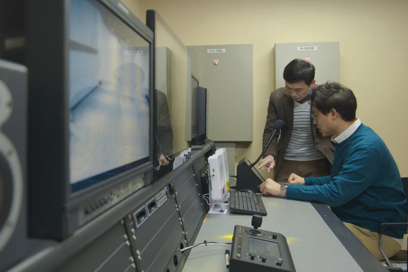 Teacher and student in front of broadcasting equipment