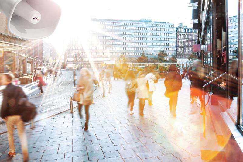 crowded city street in blurry sunlight, AXIS c1310e in the top left corner