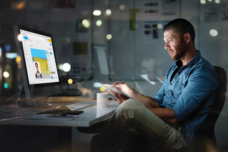 Business man working late in front of screen