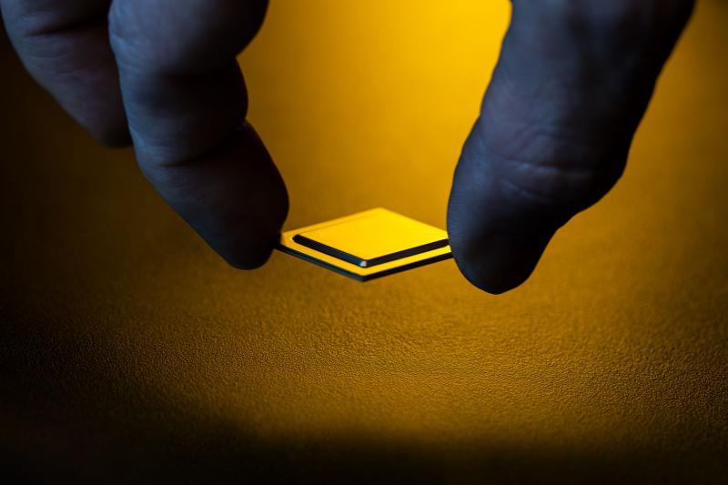 hand holding a chip, yellow backlight