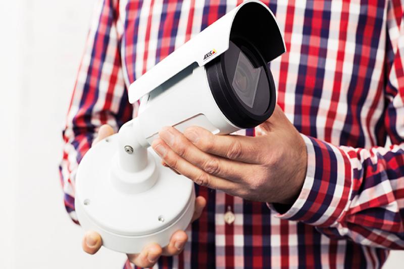 close up on a man in a red shirt holding a camera