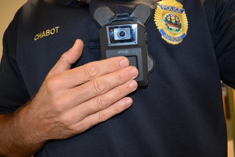 Close up of officer pushing button on Body Worn camera