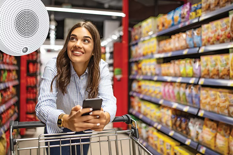 Person with dark hair walking with a cart in store