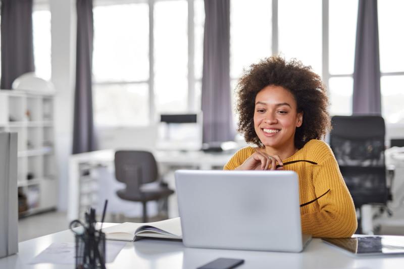 Woman sitting in office with a laptop