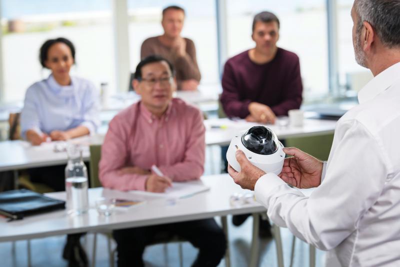 Man holding camera in front of class