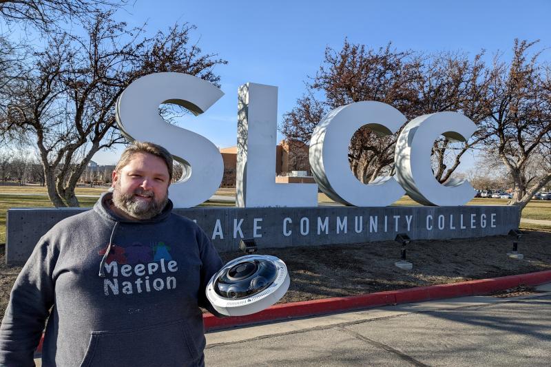 Security director holds Axis camera in front of Salt Lake Community College