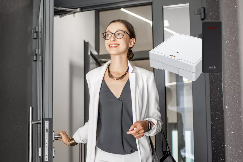 Person walking through a entrence door, wearning glasses and brown hair.