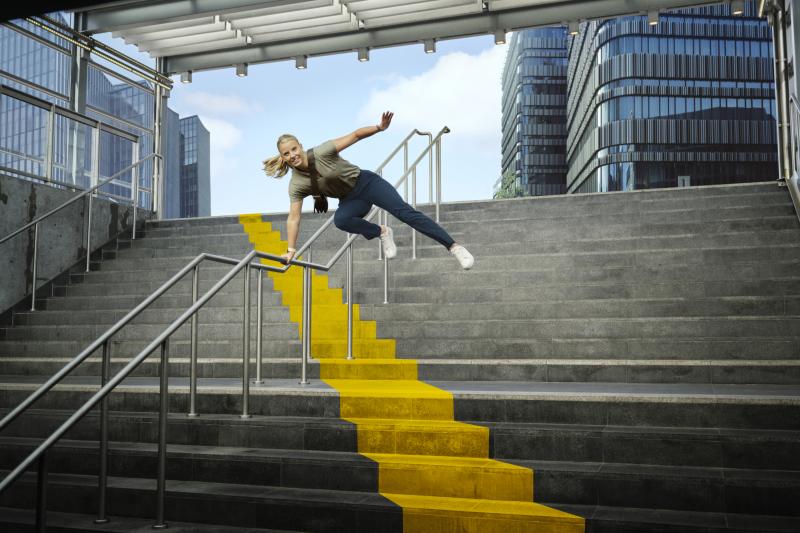 Person jumping over the railing that leads down stairs