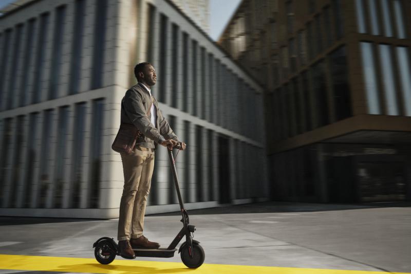 Person riding an electrical scooter outside of a building 