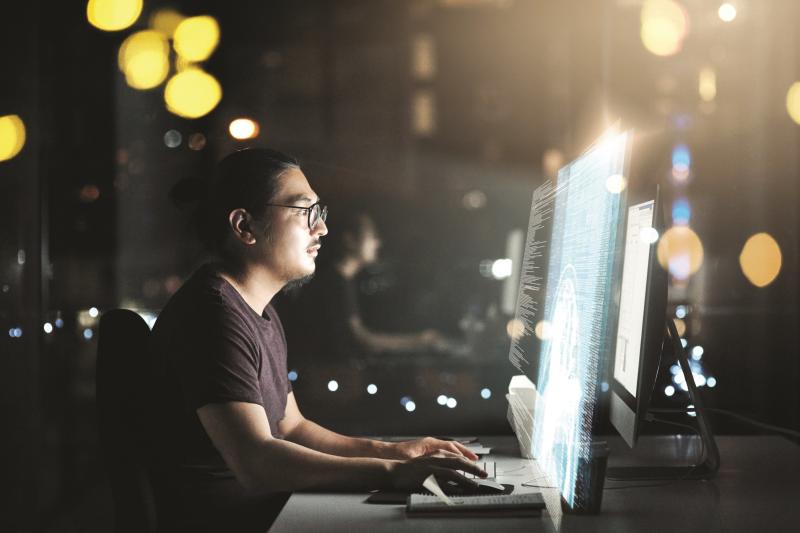 Person working night shift at an office in front of screens.