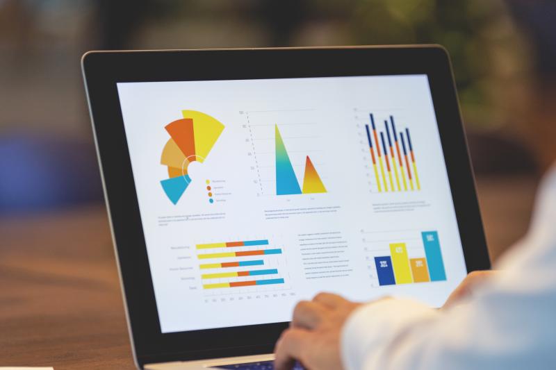 Businessman using laptop with graphs charts