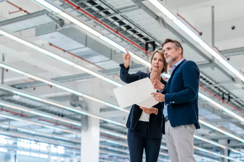 Woman and man discussing in warehouse cropped