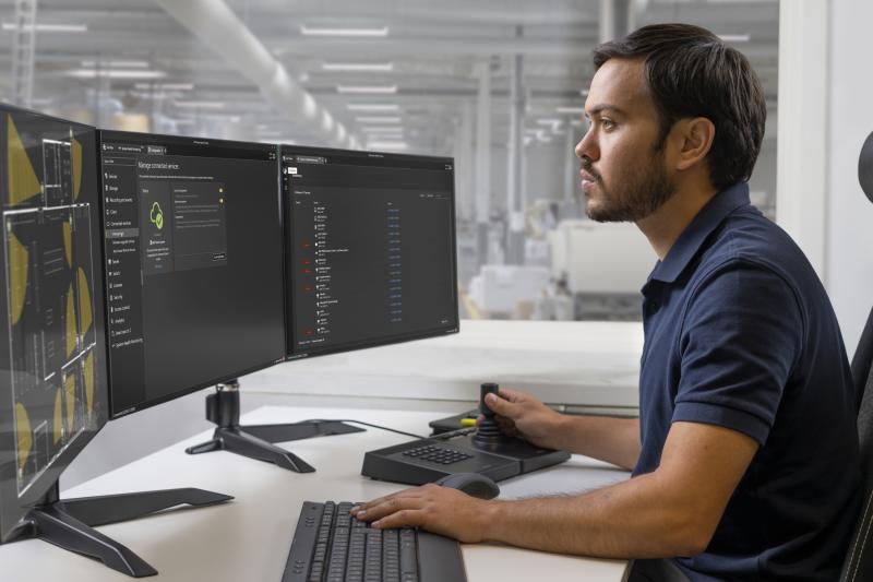 man sitting in front of axis camera station, interface showing successful connection to cloud