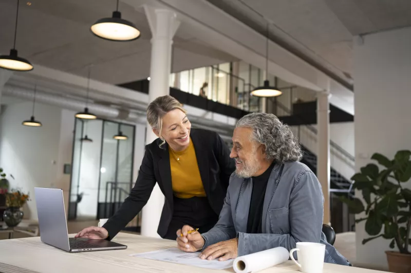 A&E woman and man collaborating on laptop in office