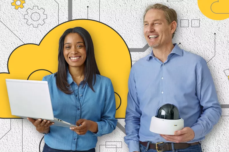 woman holding a laptop, beside a man holding a camera, behind a wall with yellow cloud illustration